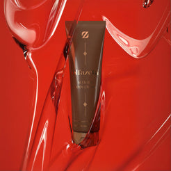 Tube de crème parfumée pour le corps Olfazeta by Chogan N°23 sur fond de gel rouge brillant aux volutes