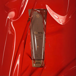 Tube of scented Olfazeta by Chogan N°23 shower gel against a glossy red gel background with fluid swirls