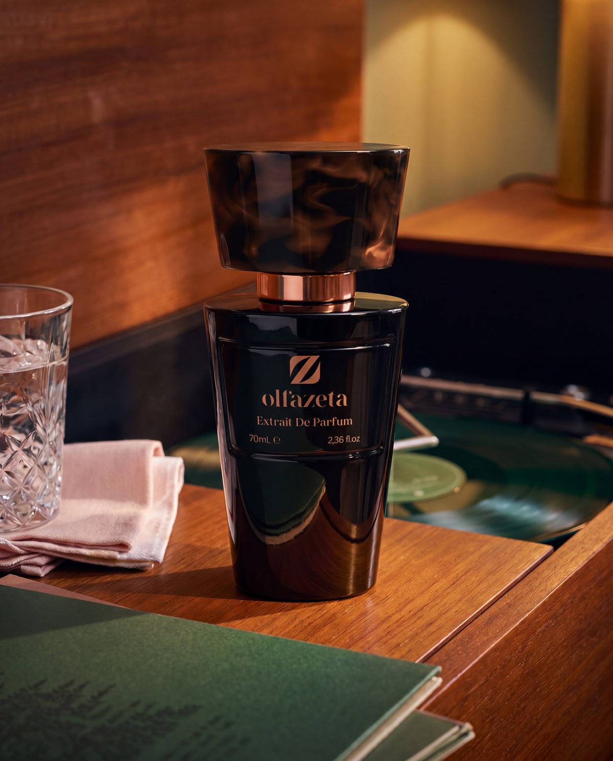 Black bottle Olfazeta by Chogan Millésime N°78 on wood, a glass with ice cubes and a turntable in a cosy atmosphere