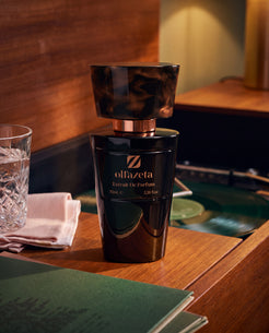 Black bottle Olfazeta by Chogan Millésime N°78 on wood, a glass with ice cubes and a turntable in a cosy atmosphere