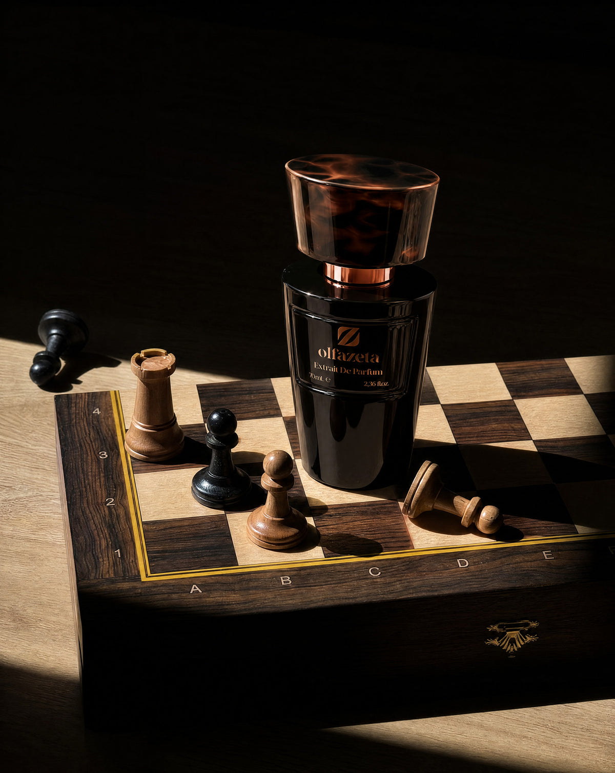 Flacon noir Olfazeta by Chogan Millésime N°31 sur un échiquier en bois entouré de pièces d'échecs