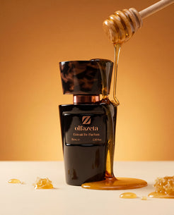 Flacon noir Olfazeta by Chogan Millésime N°37 arrosé de miel doré coulant d'une cuillère, fond ambré