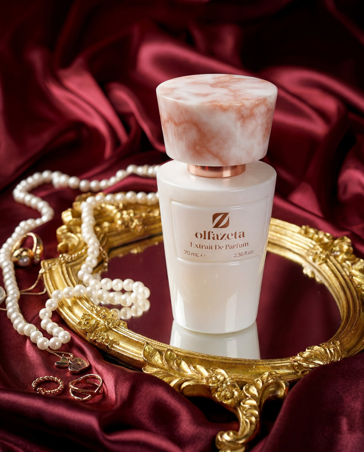 White Olfazeta by Chogan Millésime N°82 bottle on a golden tray, pearls and jewellery on burgundy satin