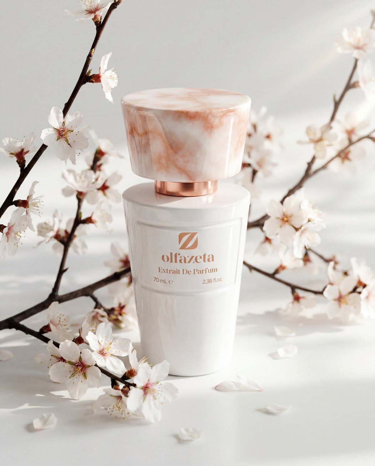 Flacon blanc Olfazeta by Chogan Millésime N°81 parmi des branches de fleurs de cerisier blanc et rose